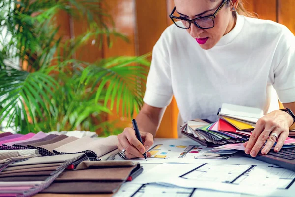 Mimar, iç mimar, ofiste malzeme örnekleme tahtasıyla çalışıyor.