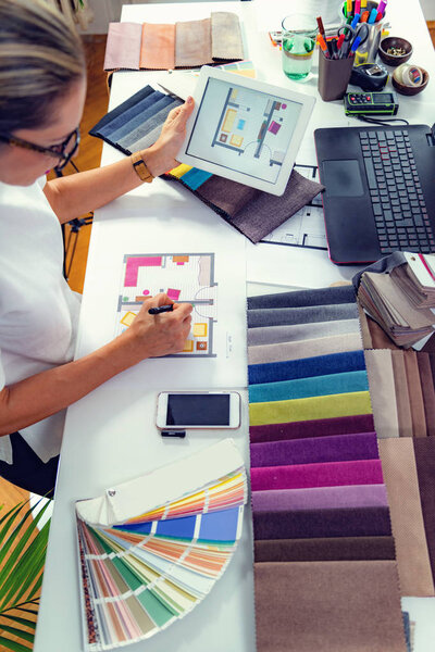 Дизайнер интерьеров, декоратор, выбор образцов материалов в студии
