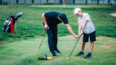 Golf Kişisel Eğitimi. Golf eğitmeni Genç Çocuğa Golf oynamayı öğretiyor.  