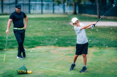 Golf Dersi. Golf Eğitmeni Genç Çocuğa Nasıl Sallanacağını Öğretiyor 