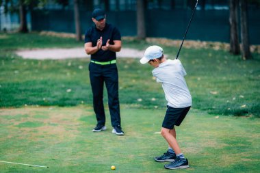 Golf Kişisel Eğitimi. Golf eğitmeni Genç Çocuğa Golf oynamayı öğretiyor.  