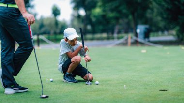 Golf öğreniyorum. Çocuk eğitmenle antrenman yapıyor.