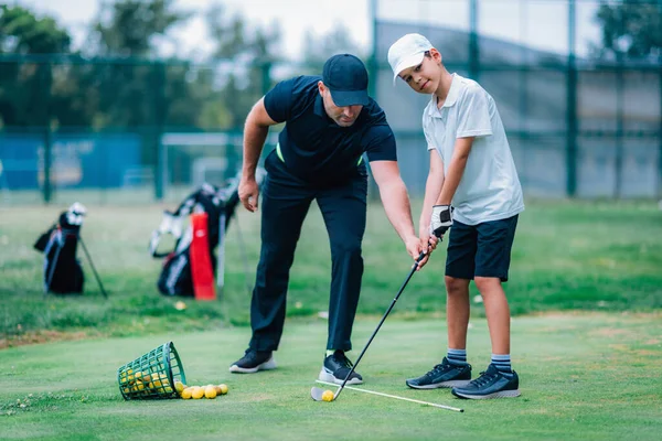 个人高尔夫课高尔夫教练 带着小男孩在高尔夫球场上 — 图库照片