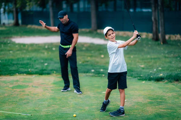 ゴルフパーソナルトレーニング ゴルフインストラクター 少年にゴルフの遊び方 — ストック写真