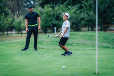 Golf Koyma Eğitimi. Golf Eğitmeni ve Genç Çocuk Golf Sahasında Çalışıyor