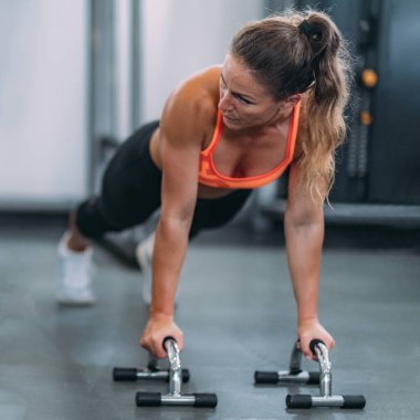Spor salonunda şınav çeken bayan sporcu.