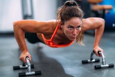 Spor salonunda şınav çeken bayan sporcu.