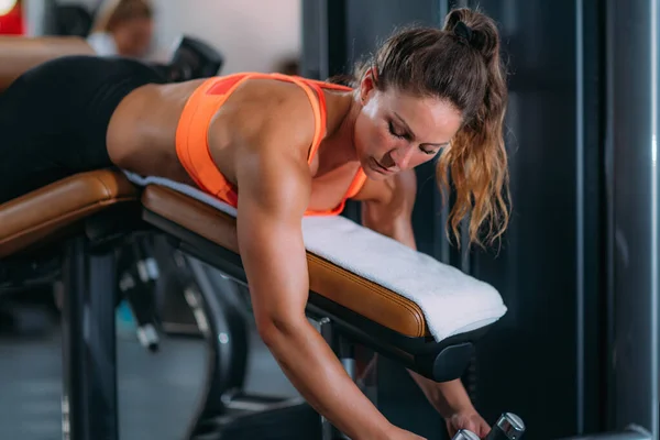 Kvinnlig Idrottsman Tränar Liying Leg Curl Bench Gymmet — Stockfoto