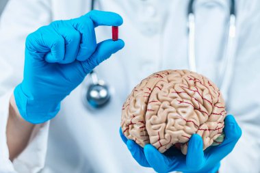 Nocebo Etkisi. Plasebo nosebo etkisini açıklayan beyin ve plasebo ilave hapların modelini tutan kadın doktor. 