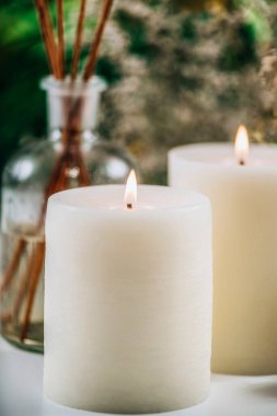 Aromaterapi konsepti. Aromatik beyaz mumlar ve temel yağ sazlığı difüzörleri