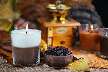 Kokulu kahve ve vanilyalı çift renkli aromalı mum ve ahşap kasede kahve.