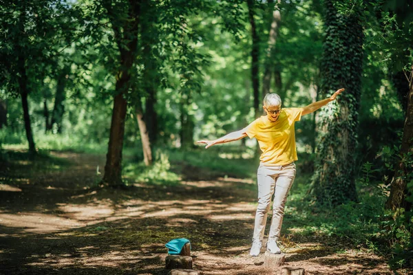 屋外でのバランス運動 片脚に立つ熟女 バランスを取ります — ストック写真