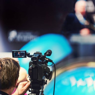 Kameraman basın toplantısında erkek konuşmacı kaydediyor. Canlı yayın kavramı.