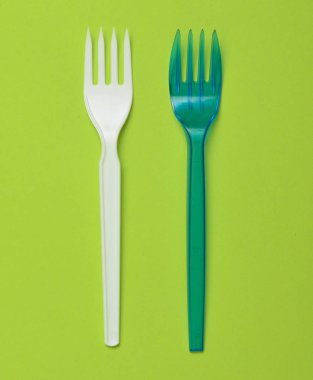 Plastik çatal piknik üzerinde yeşil bir arka plan için. Minimalist eğilim. Üstten görünüm