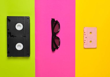 Video kaset, güneş gözlüğü, çok renkli kağıt arka plan üzerinde ses kaset. Minimalist eğilim, düz yatıyordu, en iyi görünümü
