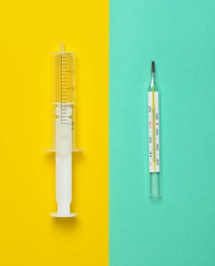 Tıbbi şırınga olmadan bir iğne ve pastel arka plan, üstten görünüm, Minimalizm bir termometre. Tıbbi donatımı