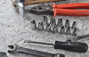 Gri beton zemin üzerine bir çalışma aracı. İngiliz anahtarları, çekiç, tornavida, pense. Üstten görünüm, kopya alanı