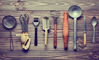 Eski mutfak aletleri ve çatal bıçak takımı ahşap bir masa üzerinde bir dizi. Vintage mutfakta yemek. Üstten görünüm.