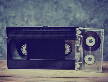 Ses ve video kaset ahşap raf bir gri beton duvara yakın çekim. Müzik ve video izlemek için retro teknoloji.