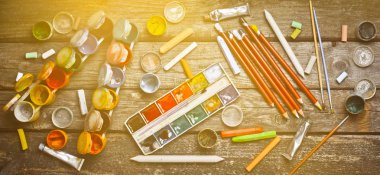 Sanatçı için araçlar. Nesneleri çizim için. Boya, boya kalemi, kalem ahşap bir masa üzerinde. Oluşturmak için ilham kaynağı. Üstten Görünüm. Düz yatıyordu.