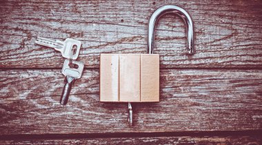 Ahşap bir masa üzerinde tuşları ile yeni bir kilit. Mülkiyet koruması kavramı. Üstten görünüm.