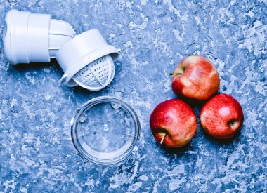 El juicer ve elma beton bir tablo. Sağlıklı gıda kavramı. Pişirme işlemi. Üstten görünüm. Rustik ve çatı stili.