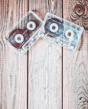Ahşap bir masa üzerinde iki ses kasetleri. Retro medya teknoloji 80s. Müzik sevgisi. Uzay kopyalayın. Üstten Görünüm.