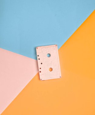 Minimalizm eğilimini. Retro ses kaset pastel pembe renk renkli kağıt arka plan üzerinde. Eski radyo sinyalleriyle iletilen teknoloji. Üstten Görünüm. Düz yatıyordu.