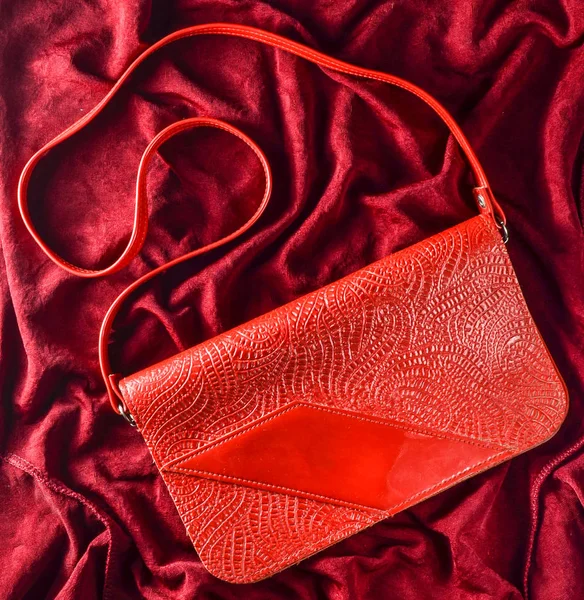 Retro red bag on a red silk background. Top view.