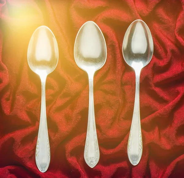 Set Three Metal Spoons Red Silk Tablecloth Top View — Stock Photo, Image