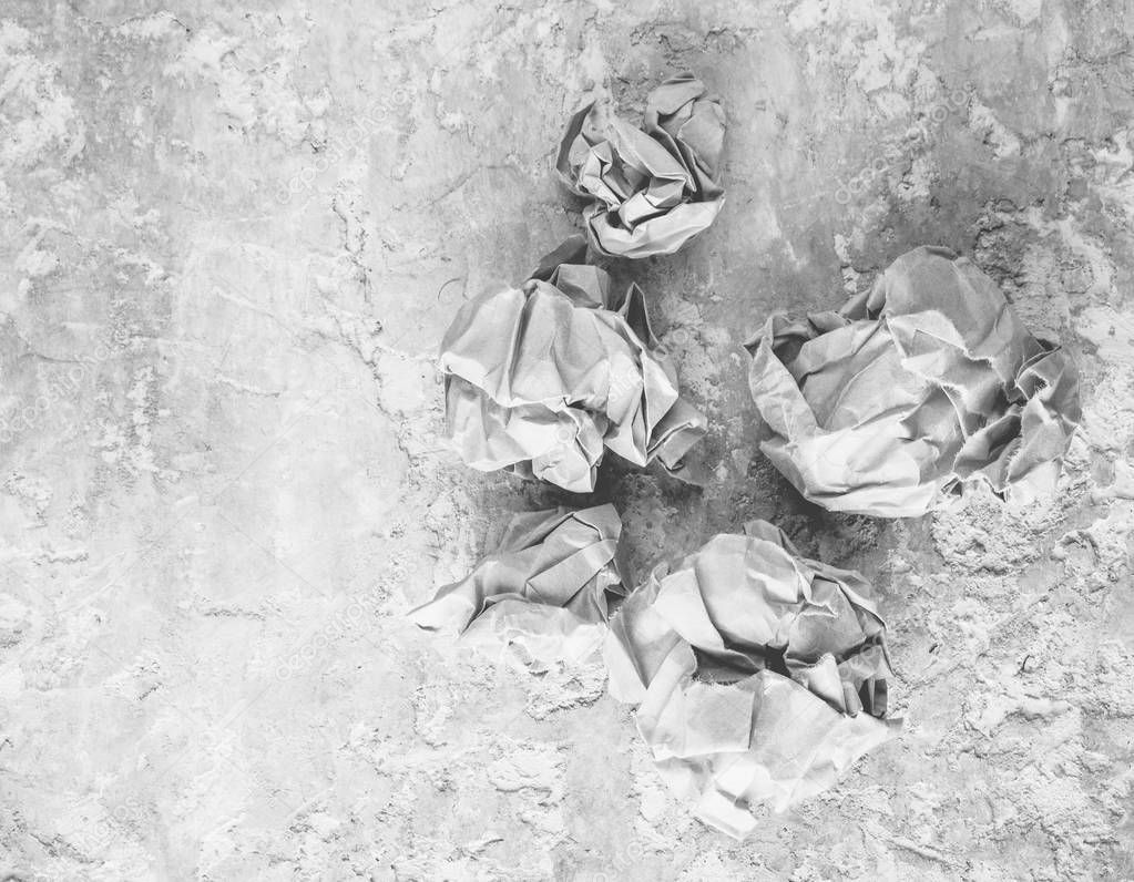 Balls of crumpled old paper on a concrete table. The concept of inappropriate, spent ideas.