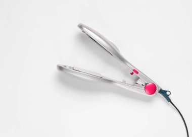 Beyaz bir arka plan üzerinde gümüş rengi için bir saç demir. Saç Bakımı.