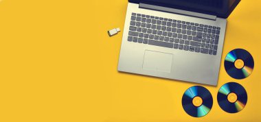 Dizüstü bilgisayar, Cd sürücüler, Usb flash sürücü sarı bir arka plan üzerinde. Modern ve eski dijital medya.