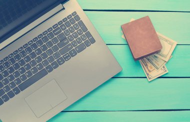Laptop ve çanta turkuaz ahşap bir masa üzerinde para ile. Internet, online iş kavramı freelancing. Üstten Görünüm.
