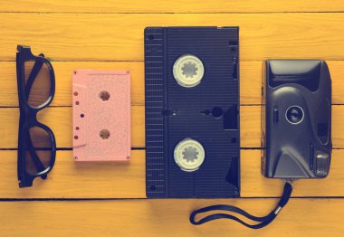 Ses Kaseti, vhs, 3d gözlük, sarı bir ahşap arka plan hipster film kamera. 80s Retro cihazlardan. Üstten Görünüm.