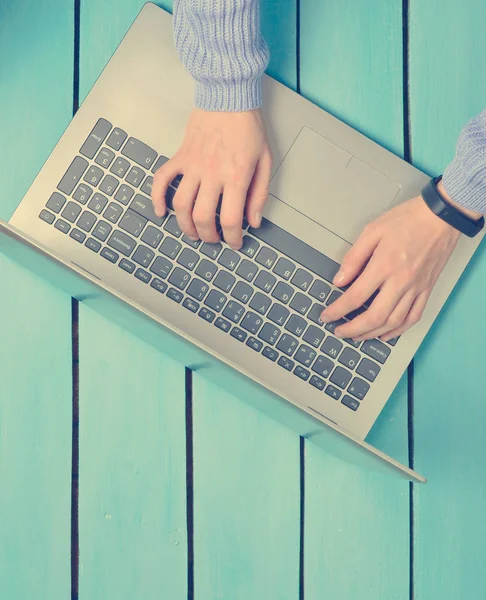 手在一个蓝色的木桌上的笔记本电脑键盘上打字 自由职业者的概念 在互联网上工作 顶部视图 复制空间 — 图库照片