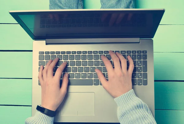 在绿松石木桌上使用笔记本电脑 顶部视图 现代青年 网上工作在互联网上 — 图库照片