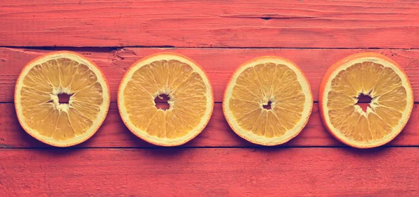 Dried orange slices on an orange wooden background. Top view.