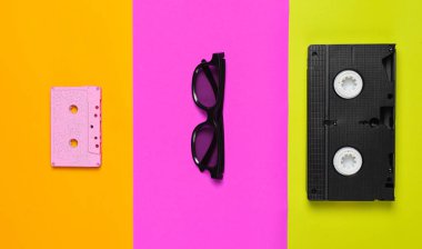 Video kaset, güneş gözlüğü, çok renkli kağıt arka plan üzerinde ses kaset. Minimalist eğilim, düz yatıyordu, en iyi görünümü