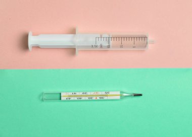 Tıbbi şırınga olmadan bir iğne ve pastel arka plan, üstten görünüm, Minimalizm bir termometre. Tıbbi donatımı