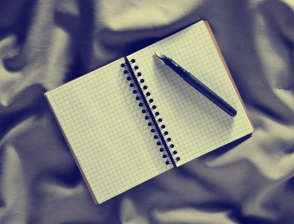 メモ帳とペン灰色の布の背景に トップ ビュー — ストック写真