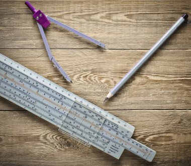 Logaritmik cetvel, pergel, ahşap bir masa üzerinde kalem. Mühendisler ve öğrenciler için ileti örneği