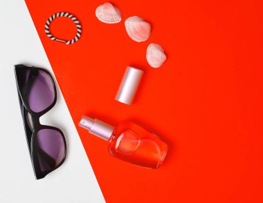 Kadın moda aksesuarları pastel sarı beyaz arka plan üzerinde. Güneş gözlüğü, parfüm şişesi, kabukları. Yaz plaj aksesuarları. Üstten görünüm, minimalist trend, kopya alanı, düz yatıyordu