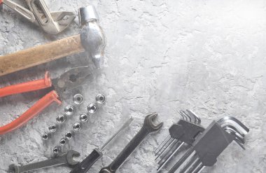Gri beton zemin üzerine bir çalışma aracı. İngiliz anahtarları, çekiç, tornavida, pense. Üstten görünüm, kopya alanı