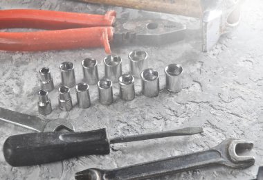 Gri beton zemin üzerine bir çalışma aracı. İngiliz anahtarları, çekiç, tornavida, pense. Üstten görünüm, kopya alanı