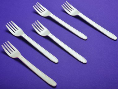 Plastik çatal kırmızı bir arka plan üzerinde piknik için. Minimalist eğilim. Üstten görünüm