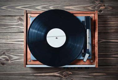 Ahşap bir masa üzerinde plakalı vinil oyuncu. Eğlence 70 lerin. Müzik dinlemek. Üstten görünüm.