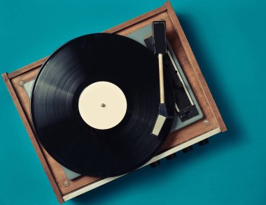 Mavi bir arka plan Retro vinil çalar. Eğlence 70 lerin. Müzik dinlemek. Üstten görünüm.