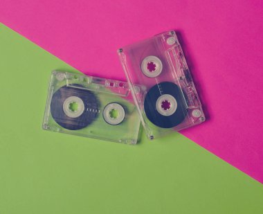Pembe yeşil neon arka plan üzerinde eski moda retro kaset. Üstten görünüm.