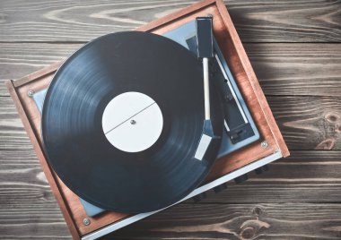 Ahşap bir masa üzerinde plakalı vinil oyuncu. Eğlence 70 lerin. Müzik dinlemek. Üstten görünüm.